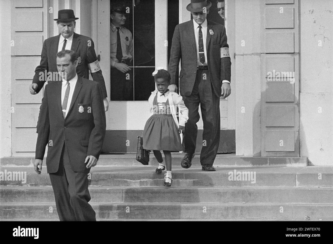 Due to threats and violence against her, U.S. Marshals escorted 6-year-old Ruby Bridges to and from the previously whites only William Frantz Elementary School in New Orleans, 1960. As soon as Bridges entered the school, white parents pulled their children out. Stock Photo