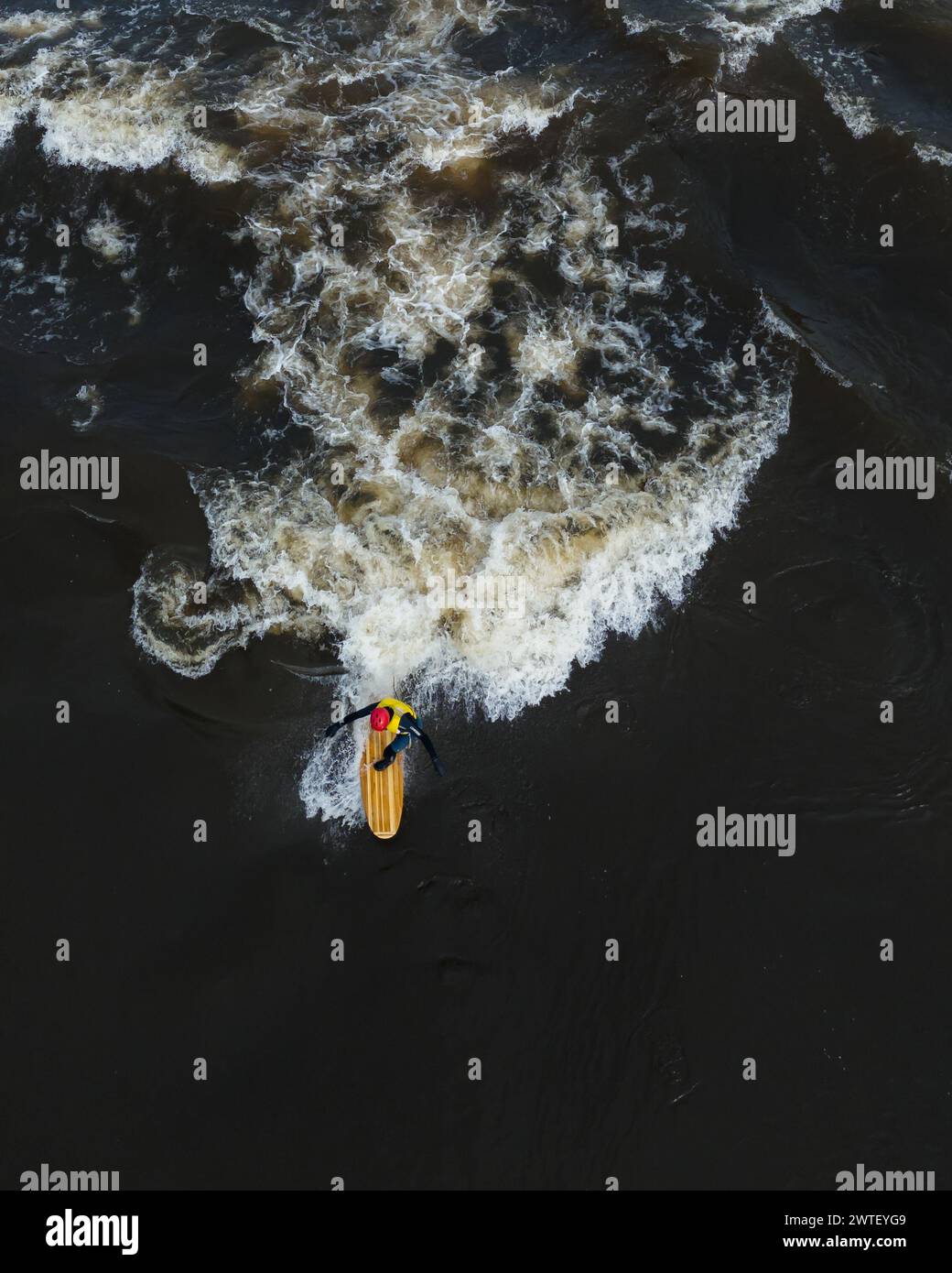 A surfer riding ocean waves on a boar Stock Photo - Alamy