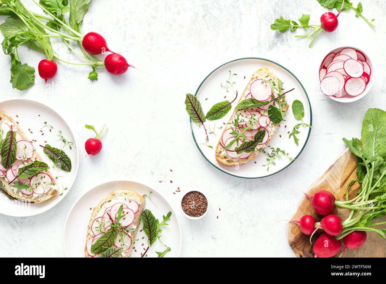 Radish sandwiches with cottage cheese and fresh green leaves, top down view Stock Photo