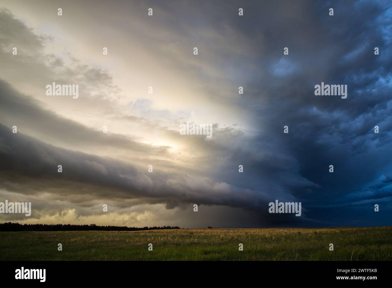 Sun shines on a layered shelf cloud as rain and storms move out of the area. Stock Photo