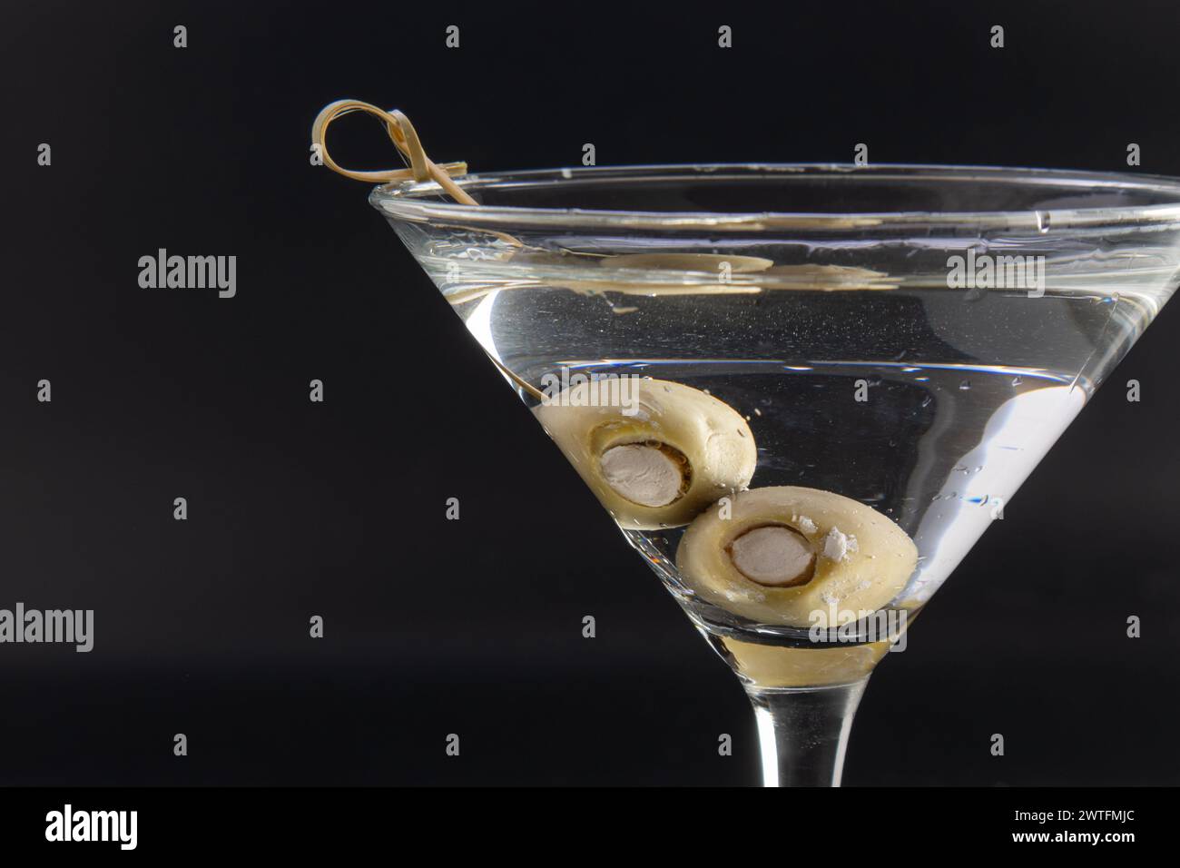 Chilled vodka martini with bleu cheese stuffed olives isolated over a