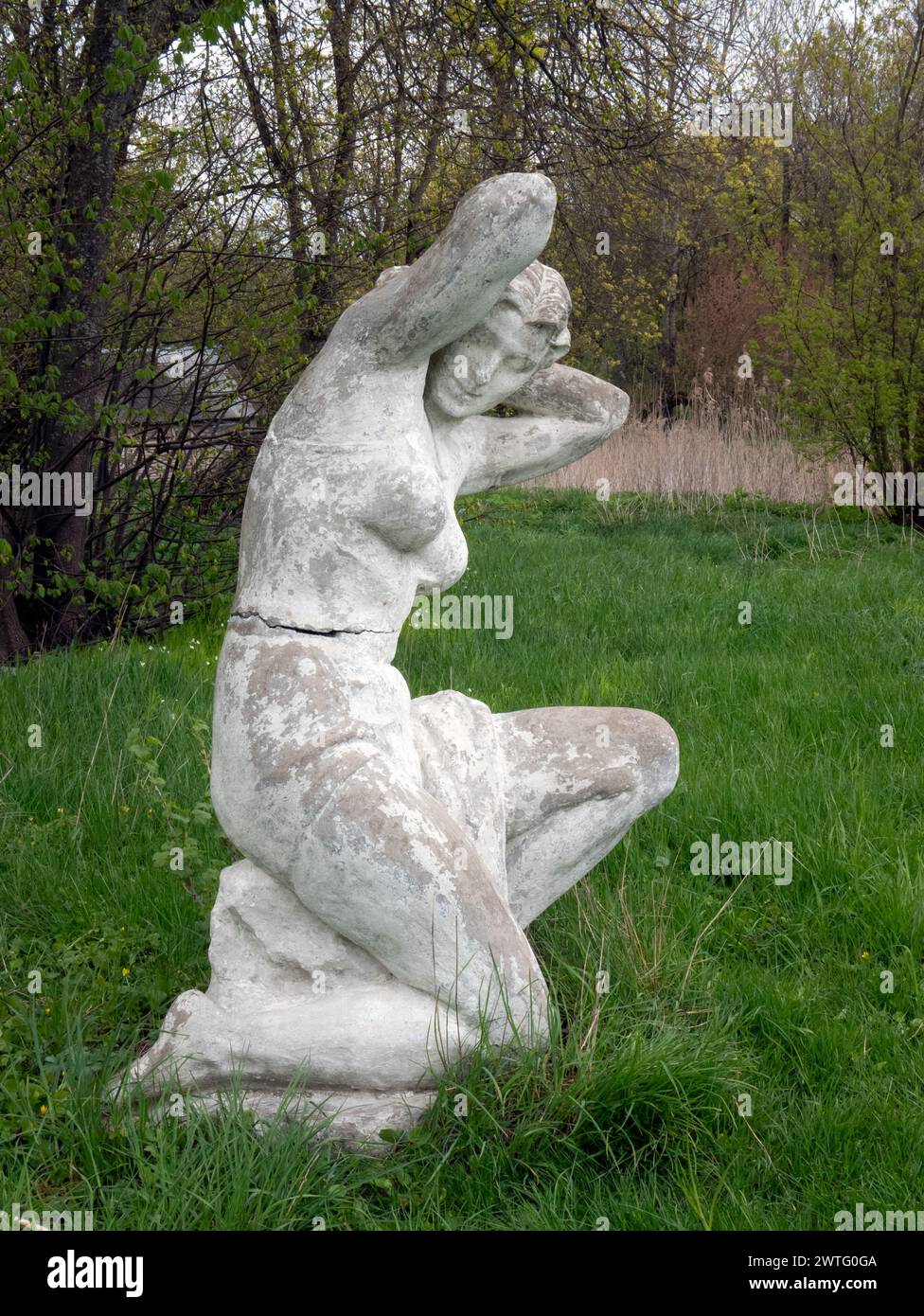 Old statue of woman after swimming in the park. Soviet monumental sculpture, selective focus Stock Photo