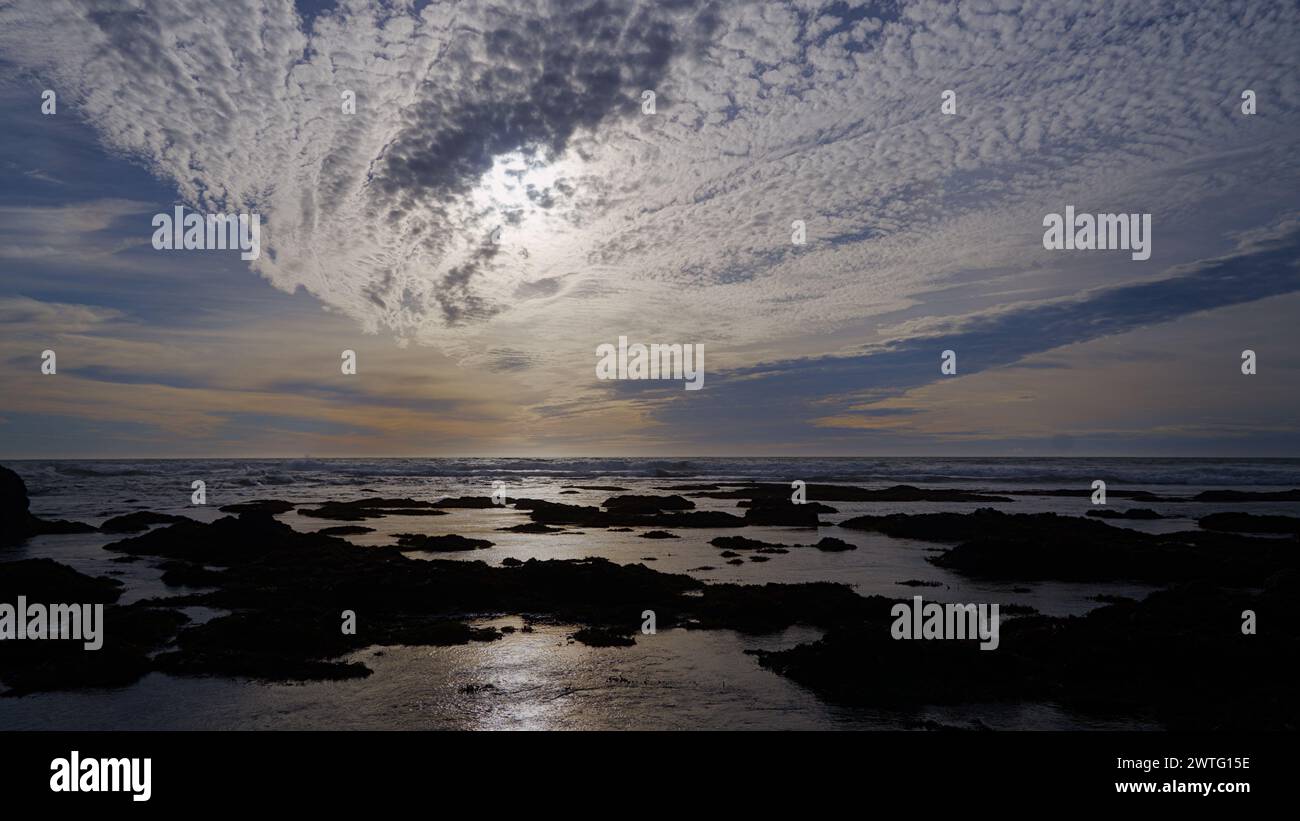 Sunset cloudy sky over the coast line. Stock Photo