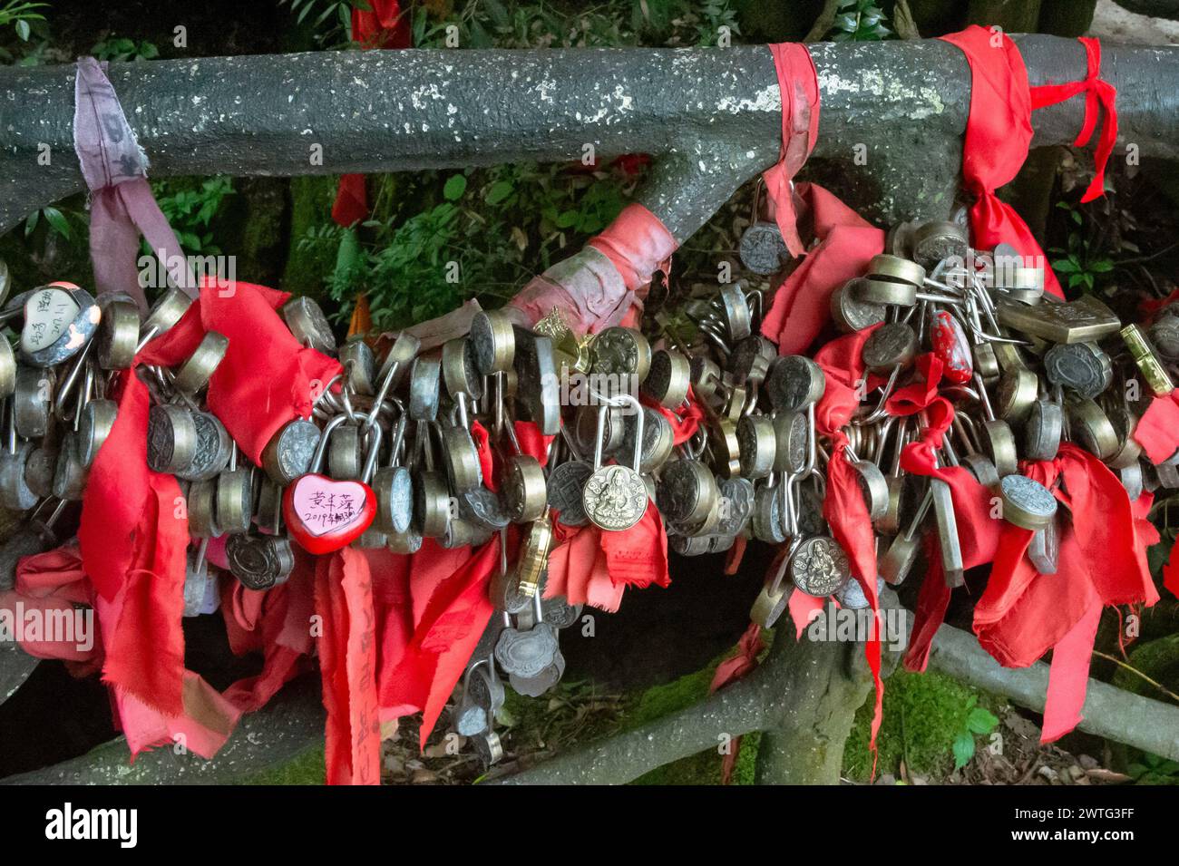 A love lock depicting Buddha hangs with many other holy padlocks in Tianmen Mountain National Park, China. Stock Photo
