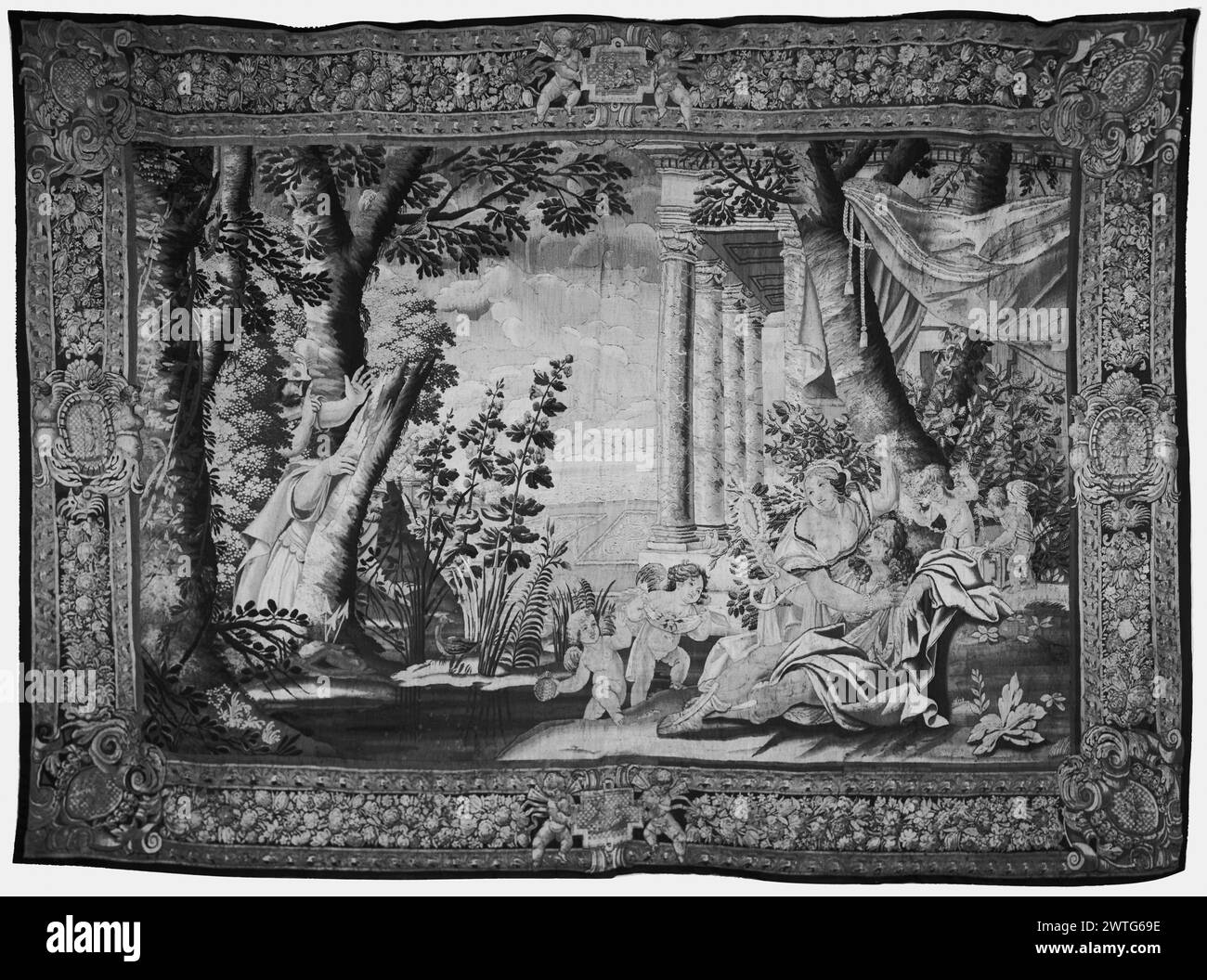 Carlo and Ubaldo find Rinaldo in Armida's garden. Vouet, Simon (French, 1590-1649) (designed after) [painter] c. 1660 Tapestry Dimensions: H 11'3' x W 15'8' Tapestry Materials/Techniques: unknown Culture: French Weaving Center: Paris Ownership History: French & Co. purchased from Mrs. Garbisch (Jack Chrysler), received 9/26/1940; sold to Alfred Jaeger 3/6/1966. Rinaldo & Armida attended by putti who bring drink of water from a stream (L) & bring jewelry from casket (R), in wooded setting with row of columns of classical building & garden park in background (BRD) floral garland; (UPR & LWR BRD) Stock Photo