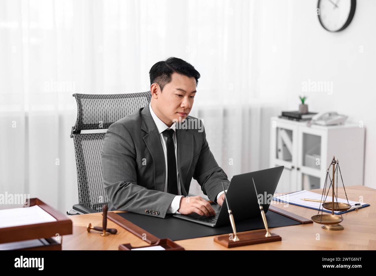 Notary working with laptop at wooden table in office Stock Photo