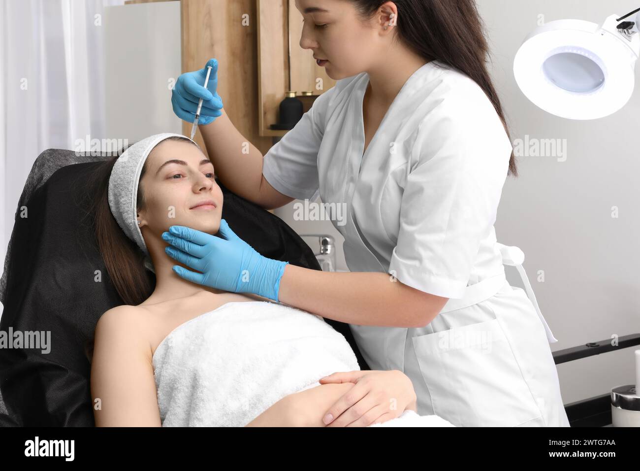 Cosmetologist giving facial injection to patient in clinic. Cosmetic surgery Stock Photo