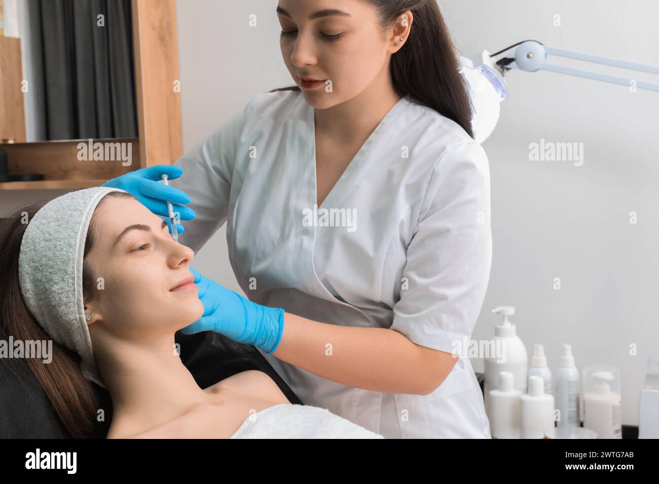 Cosmetologist giving facial injection to patient in clinic. Cosmetic surgery Stock Photo