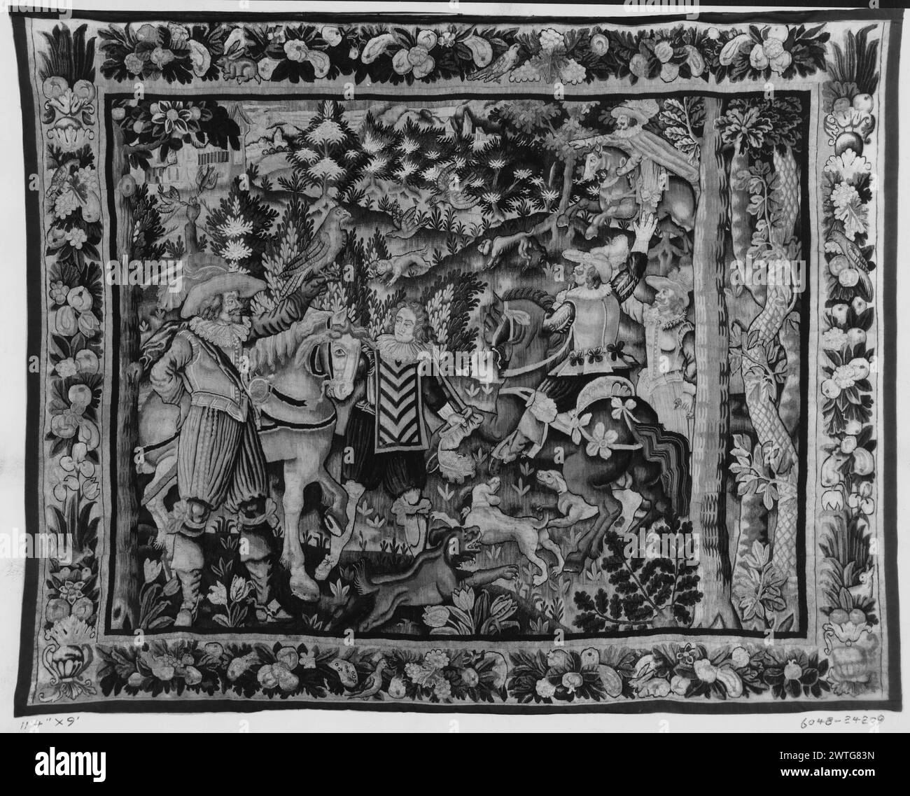 Landscape with gentlemen hawking. unknown c. 1625-1650 Tapestry Dimensions: H 9' x W 11'4' Tapestry Materials/Techniques: unknown Culture: French Weaving Center: Aubusson Ownership History: French & Co. purchased from J. T. Pratt, received 2/17/1922 (written in pen: 10/9/1929); sold to Henri Van Hove 3/31/1956. In landscape with fruit trees & flowering plants, elegantly dressed horsemen hawking with pack of hound dogs (R); falconer dismounted with bird on his arm & next to groom holding horse (L); building in distance (BRD) garland of fruit with flowers & acanthus leaves, interspersed with bir Stock Photo