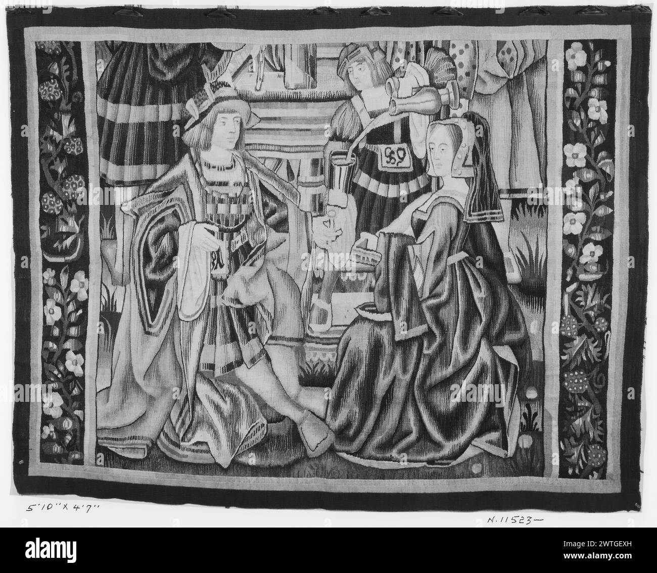 Court scene . unknown c. 1500-1520 Tapestry Dimensions: H 4'7' x W 5'10' Tapestry Materials/Techniques: unknown Culture: Southern Netherlands Weaving Center: unknown Ownership History: French & Co. purchased from Henry Symons Inc. 9/22/192[7?]. Lady & noblemen sitting next to one another, served glass of wine from vessel by servant; other [cropped] figures in background (L & R BRD) twisting vines with oversize flowers Tapestry appears to be cropped at both the top & bottom, & the upper & lower borders are missing. French & Co. stock sheet in archive, 15281 Stock Photo