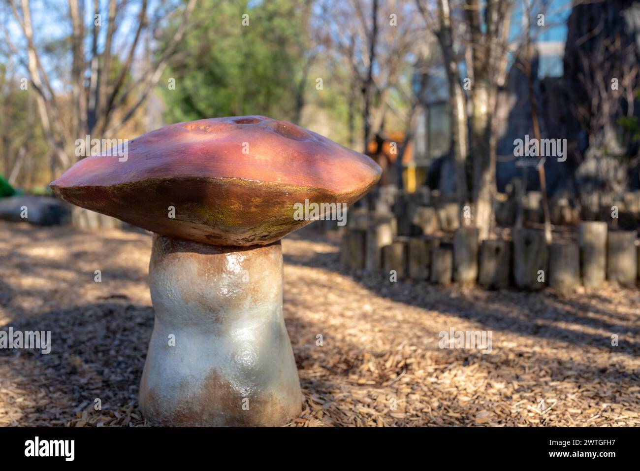 Side view of a custom children's playground seats, bench, in the shape of a toadstool or mushroom. Stock Photo