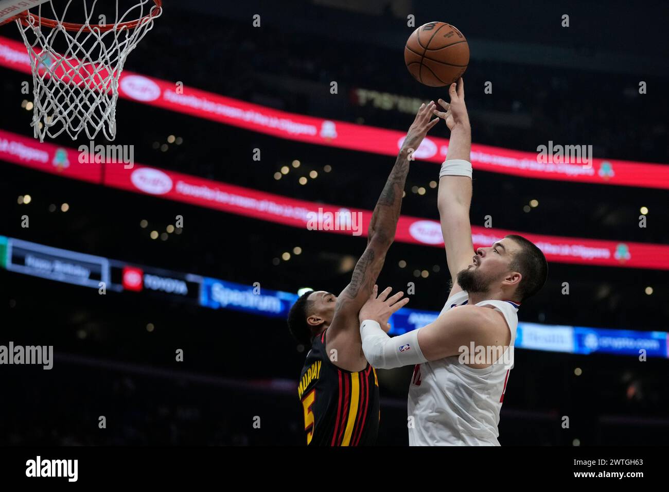 Los Angeles Clippers center Ivica Zubac, right, shoots against Atlanta Hawks guard Dejounte Murray (5) during the second half of an NBA basketball game in Los Angeles, Sunday, March 17, 2024. (AP Photo/Ashley Landis) Stock Photo