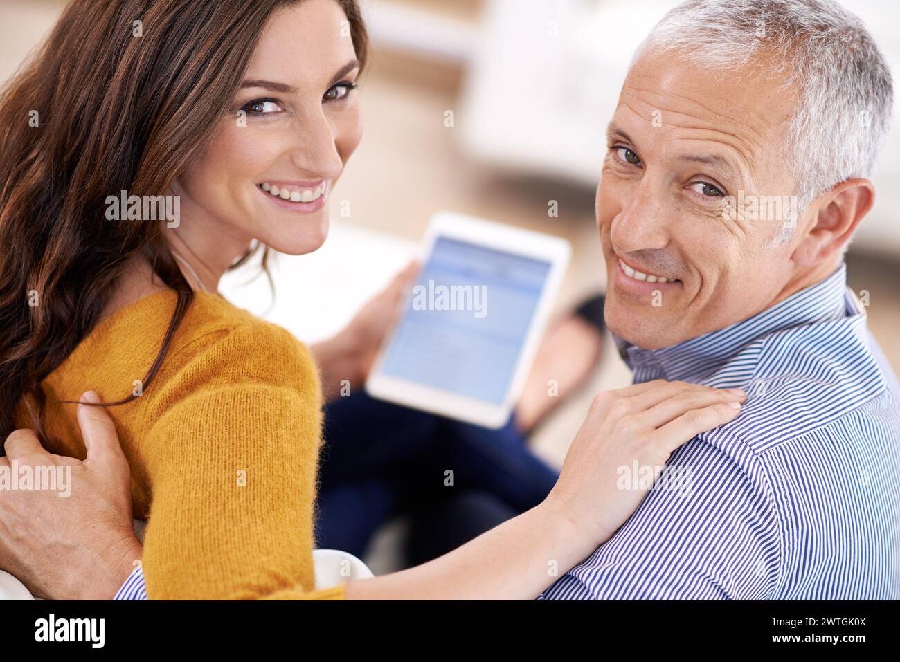 Couple, portrait and happy with tablet in home with hug for bonding, screen and relax with social media or internet. Senior man, woman or face with Stock Photo