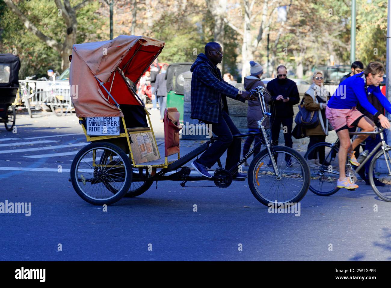 Central Park, A pedicab driver moves along a busy city street, Manhattan, New York City, New York, USA, North America Stock Photo