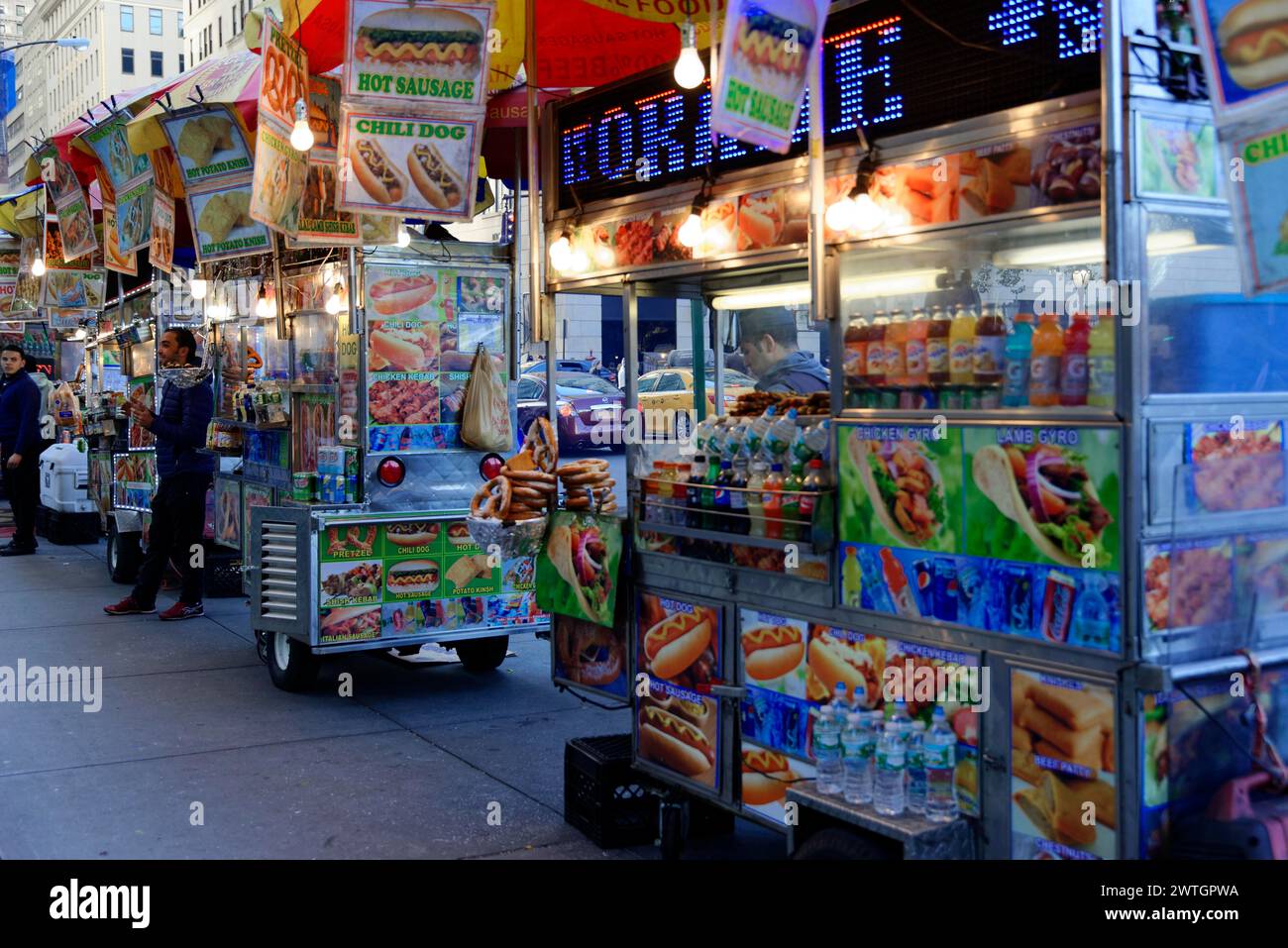 Colourful illuminated food stall offering hot dogs and snacks in a big city, Manhattan, New York City, New York, USA, North America Stock Photo