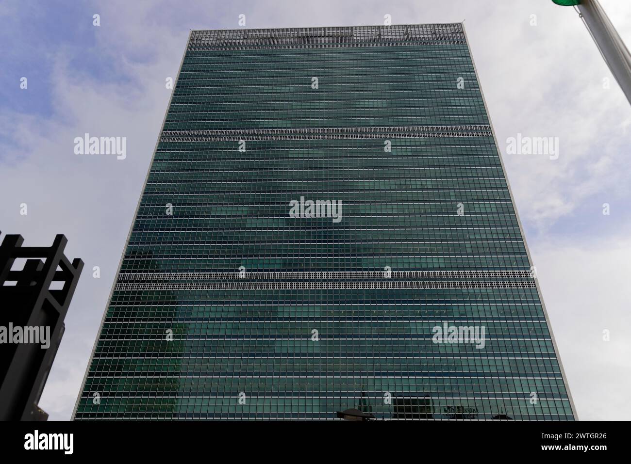 UN Headquarters, East River, A modern skyscraper with a glass facade rises into a cloudy sky, Manhattan, New York City, New York, USA, North America Stock Photo