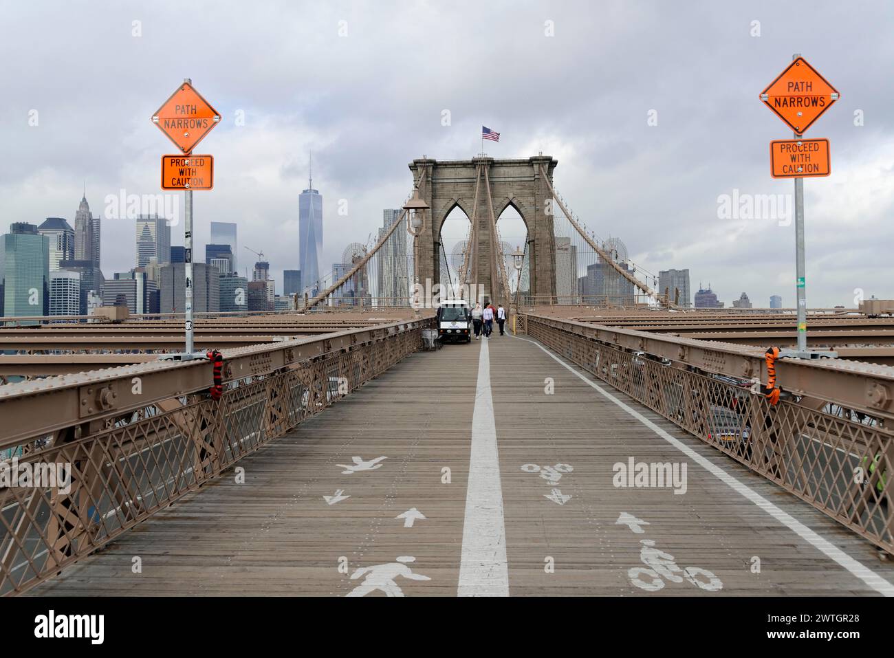 View of the Brooklyn Bridge pedestrian and cycle path with signs and skyline in the background, Manhattan, New York City, New York, USA, North America Stock Photo