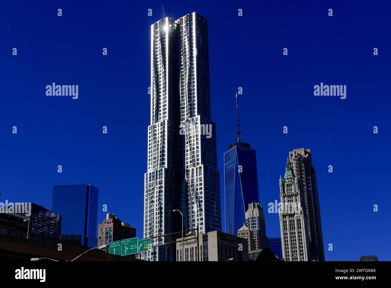 A slender skyscraper rises into the blue sky, the sun shines on its facade, Manhattan, New York City, New York, USA, North America Stock Photo