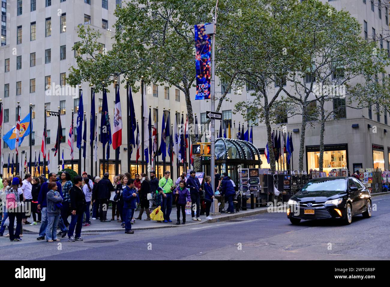 Crowd in front of buildings on a city street with numerous flags, Manhattan, New York City, New York, USA, North America Stock Photo