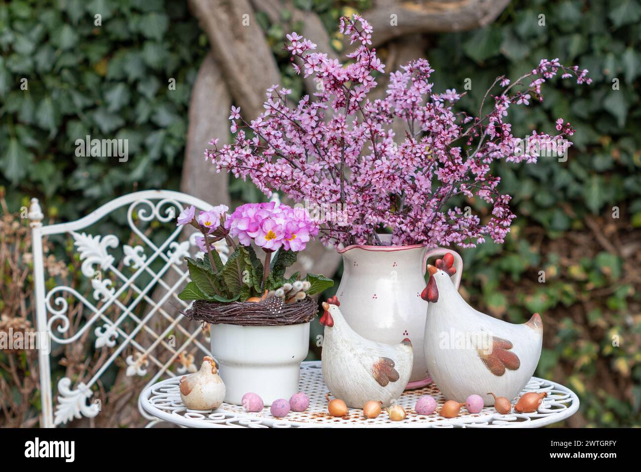 easter arrangement with bouquet of purple-leaf plum, pink primula elatior and easter chickens Stock Photo