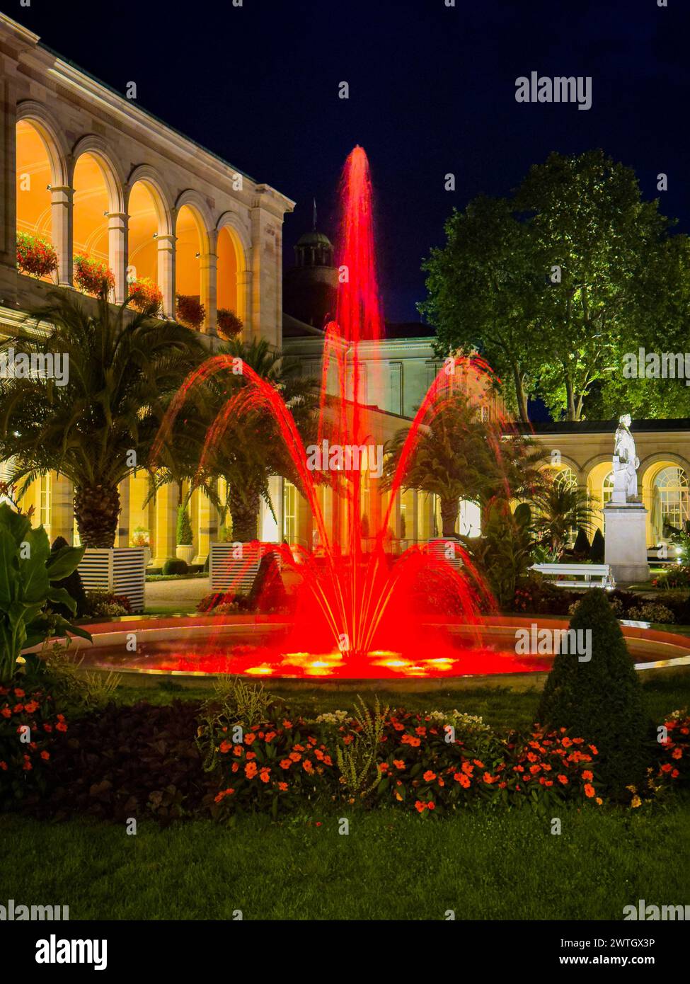 A fountain with red lights in Bad Kissingen Kurpark Park at night. Stock Photo