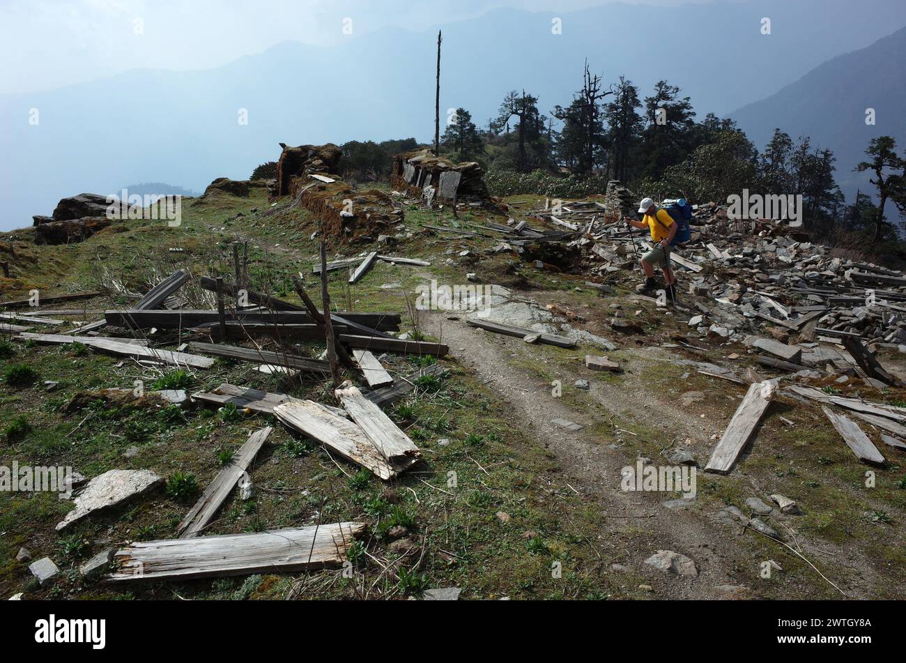 Trekking in Nepal Himalayas. Male tourist hiking on ruins of old village destroyed in earthquake 2015 on trail between Jiri and Lukla - lower part of Stock Photo