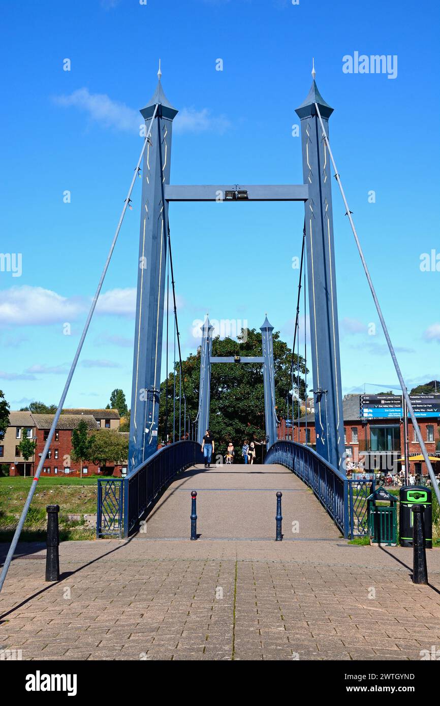 People walking over the Cricklepit suspension bridge crossing the River Exe, Exeter, Devon, AuUK, Europe. Stock Photo