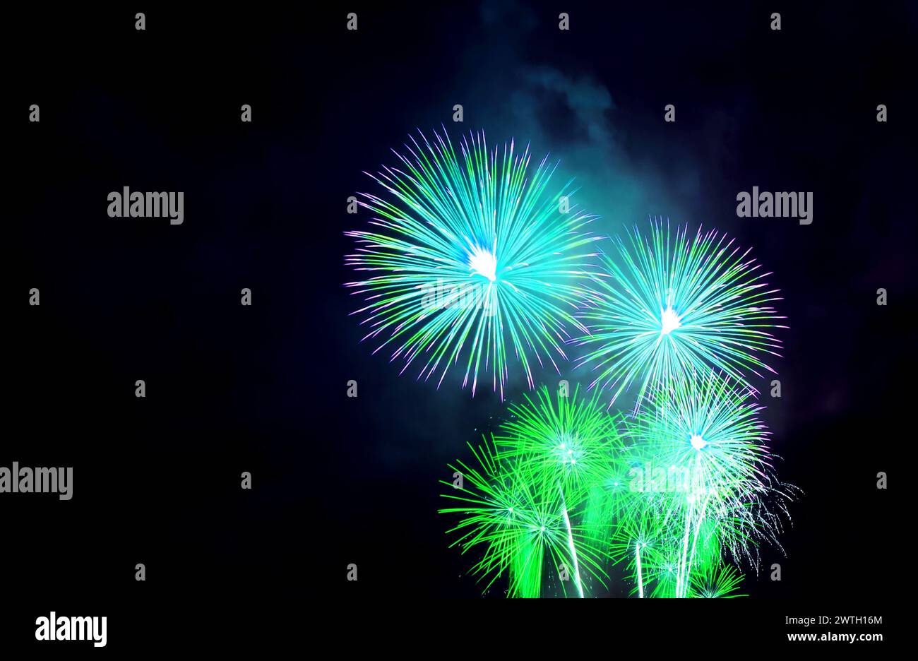 Stunning Vibrant blue and green fireworks exploding in to the night sky ...