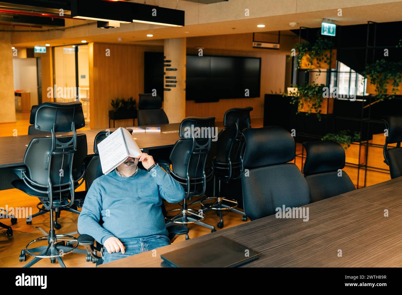 man is tired of working at the computer and is resting at workplace Stock Photo