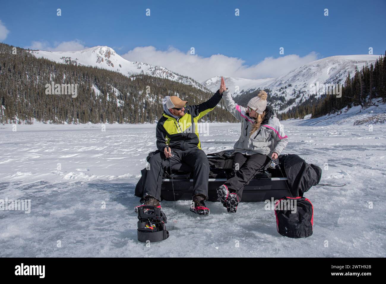 Man and woman celebrate their ice fishing adventure Stock Photo