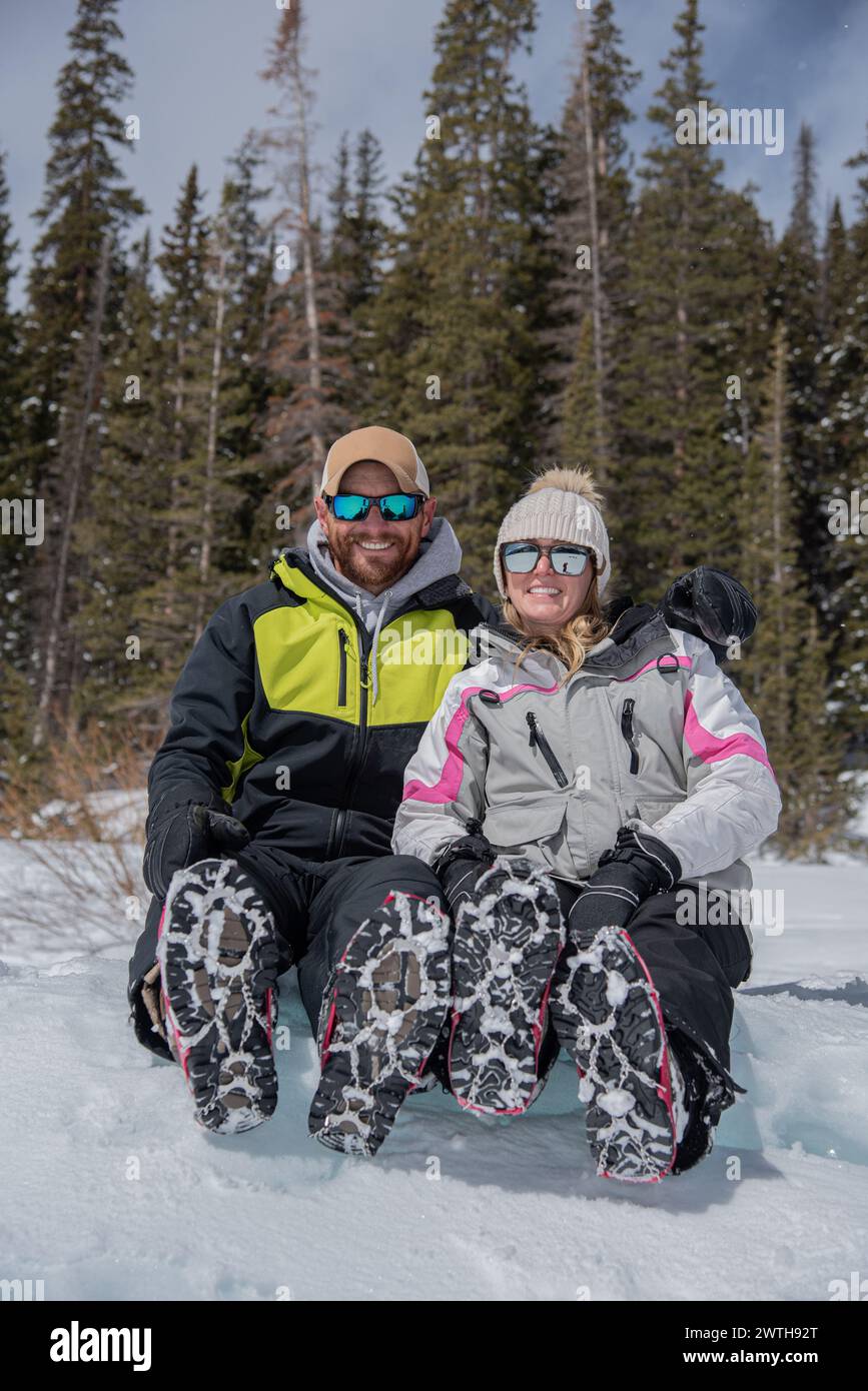 Man and woman pose for the camera during an ice fishing adventure Stock Photo