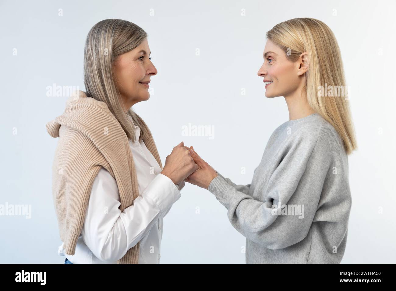 Mother and daughter standing close and holding hands Stock Photo - Alamy