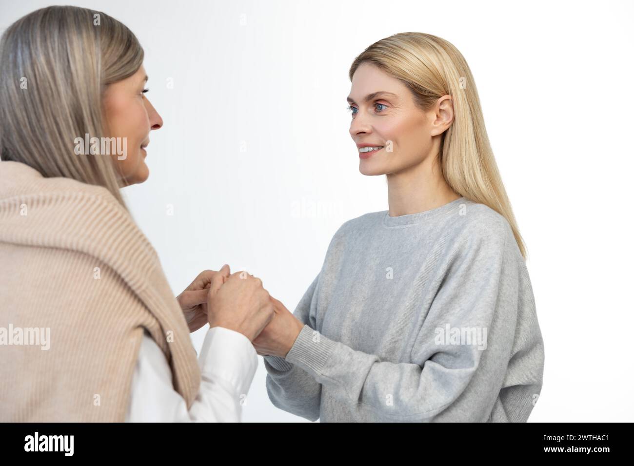 Mother and daughter standing close and holding hands Stock Photo - Alamy