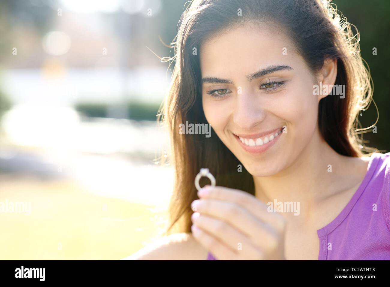 Happy fiancee checking engagement ring in a park Stock Photo