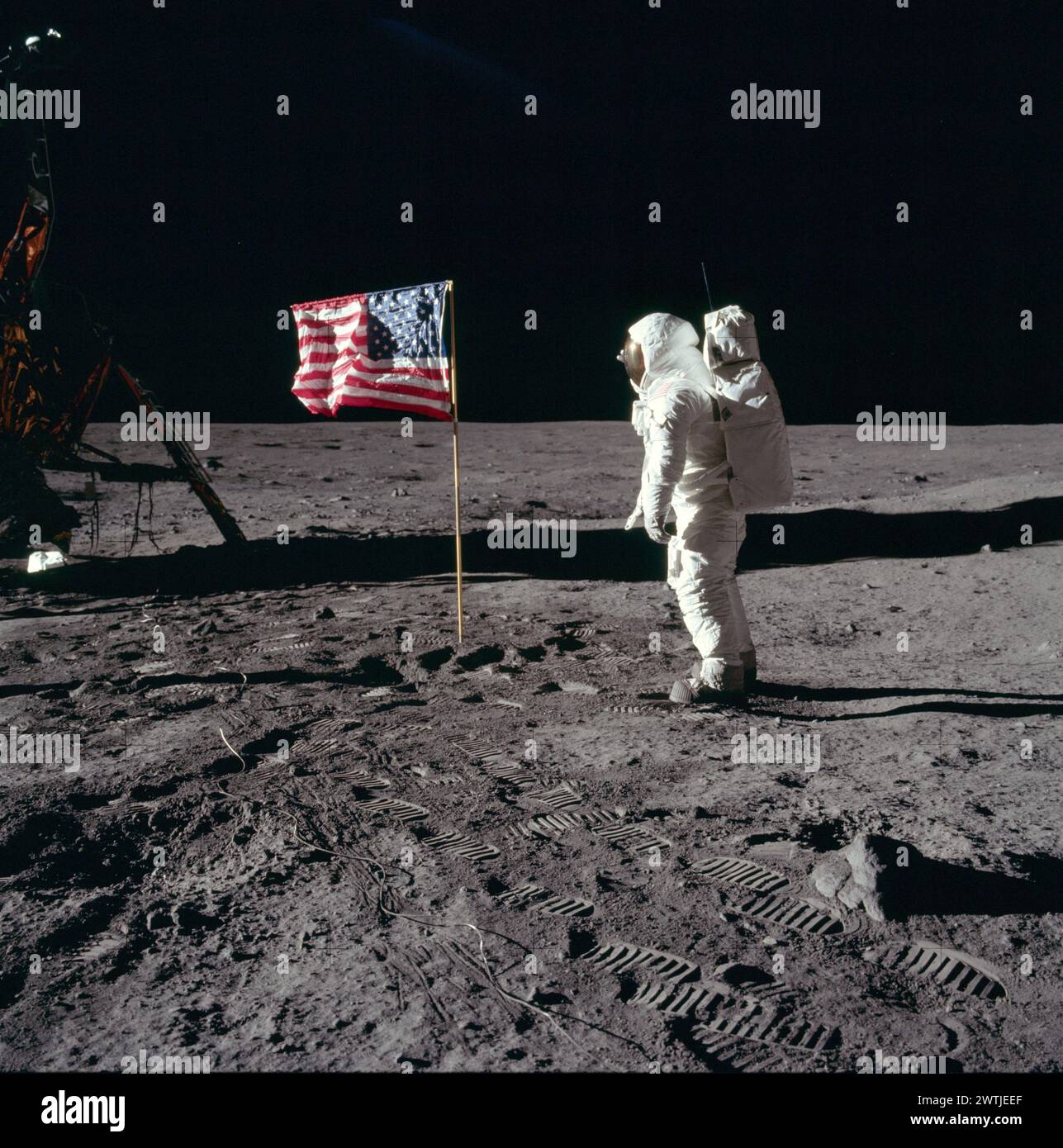The United States reached the Moon in 1969. / Neil A. Armstrong - Apollo 11  Buzz Aldrin salutes the U.S flag on the Moon (mission time: 110:10:33). His fingertips are visible on the far side of his faceplate. Note the well-defined footprints in the foregr Stock Photo