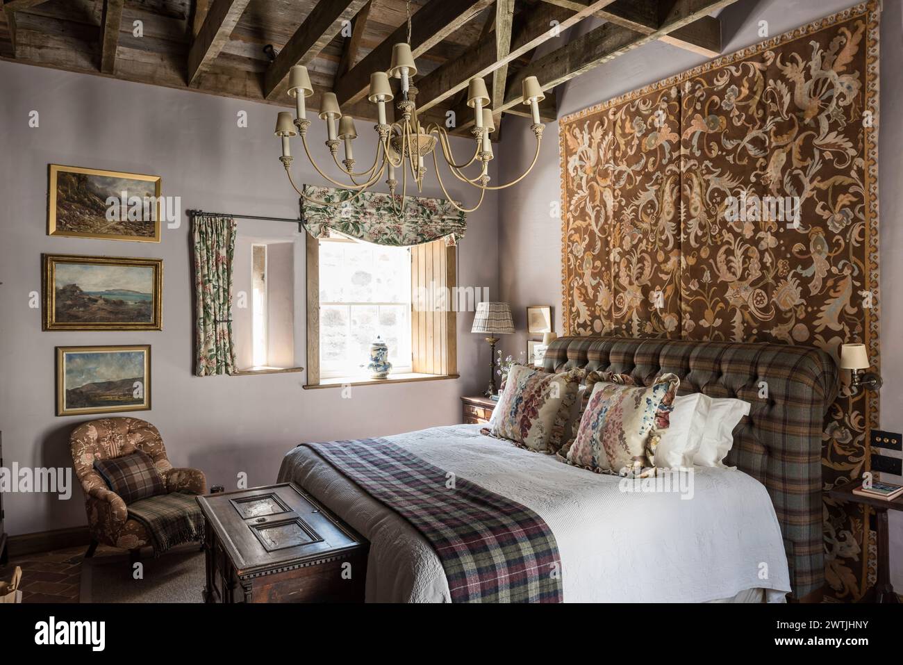 Tapestry wall hanging and candelabra in bedroom of luxury hotel in Ardfin on the Isle of Jura, Inner Hebrides, Scotland, UK Stock Photo