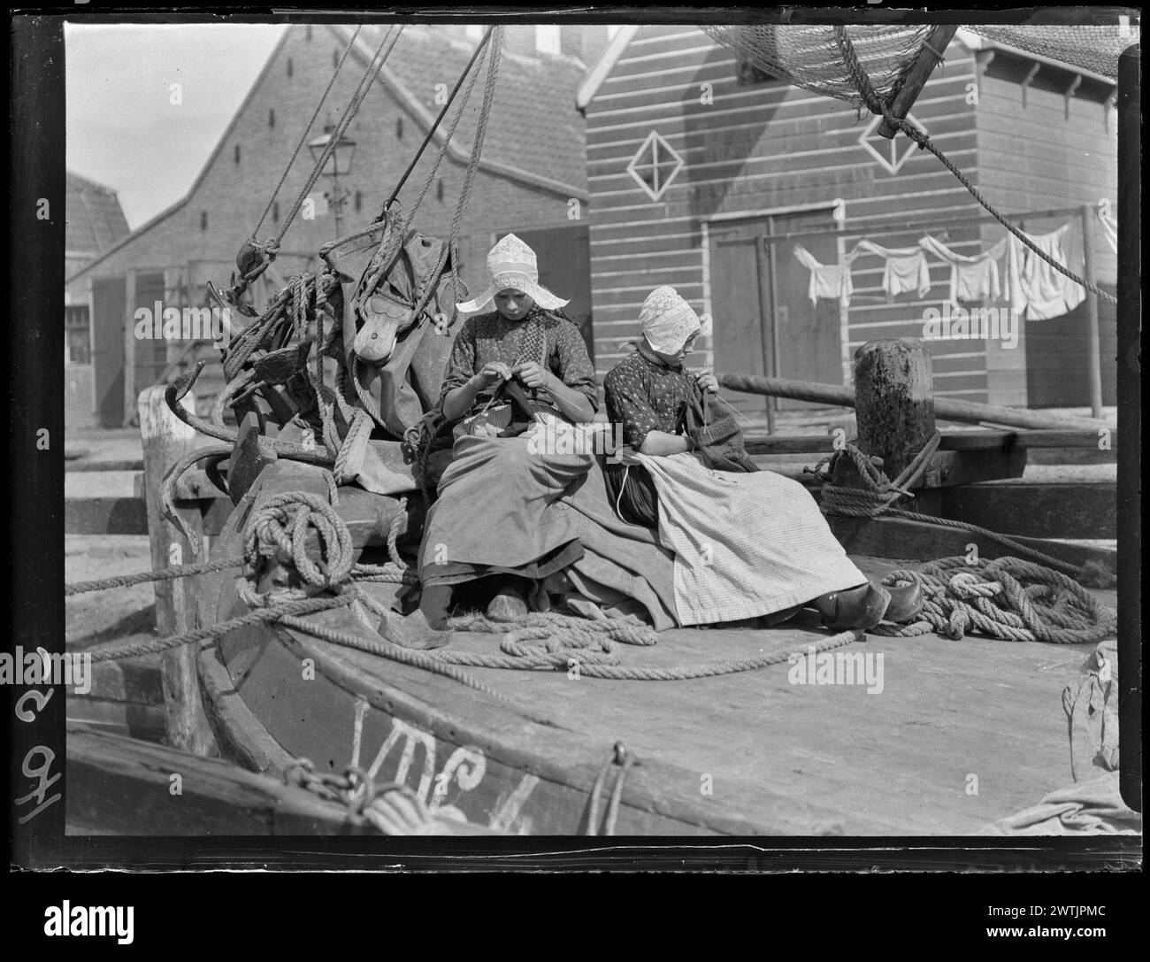 Two young women knitting on canal boat, Netherlands gelatin dry plate