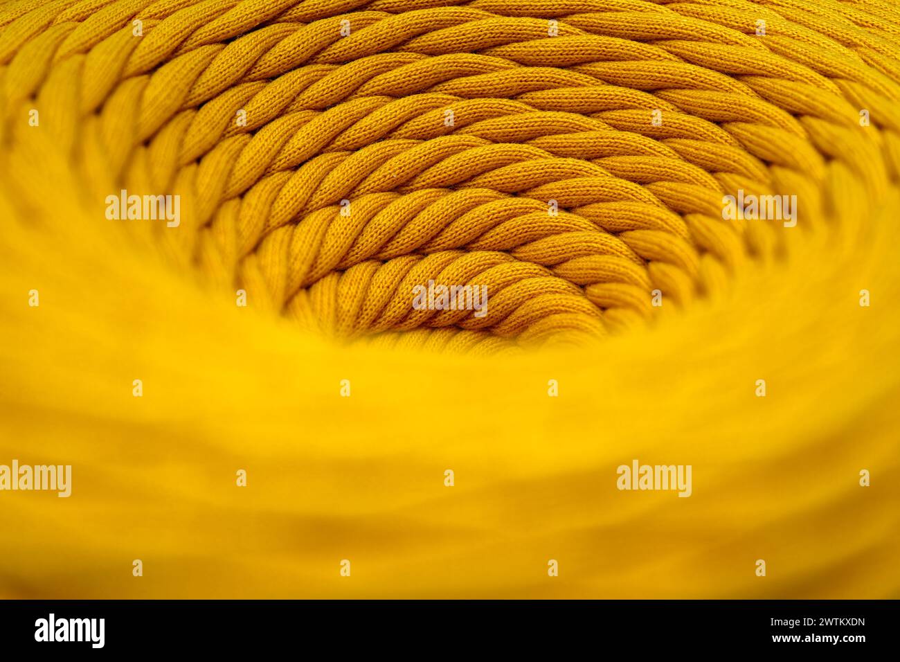 Skein of yellow braided synthetic cord, close-up shot, selective focus, abstract textile industry background Stock Photo