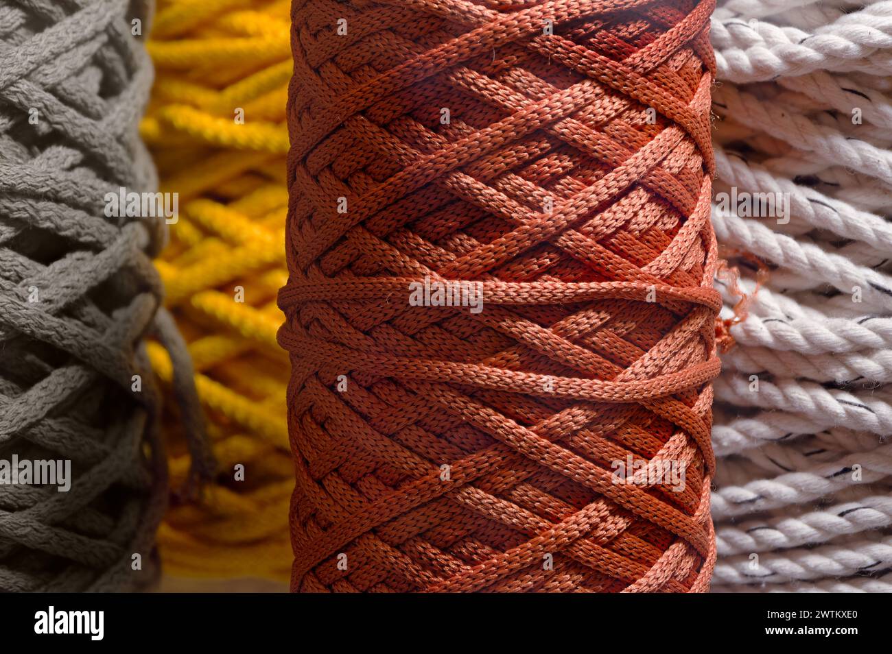 Assorted skeins of multi-coloured braided synthetic cord, abstract textile industry background Stock Photo