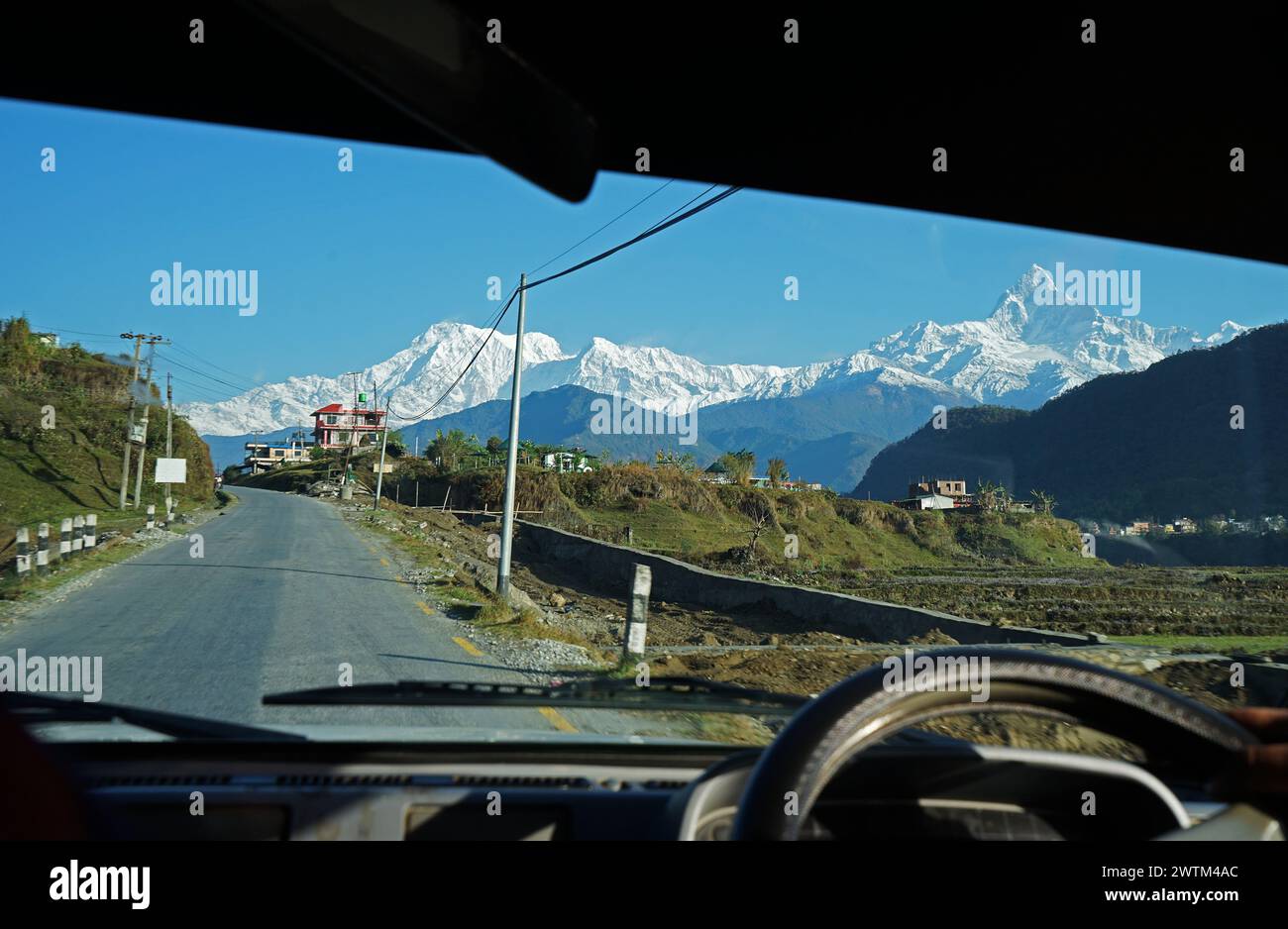 Natural landscape view of Machhapuchhre snowcapped hill ridge and Annapurna in Himalayas mountain range from front car shield- Pokhara, Nepal Stock Photo