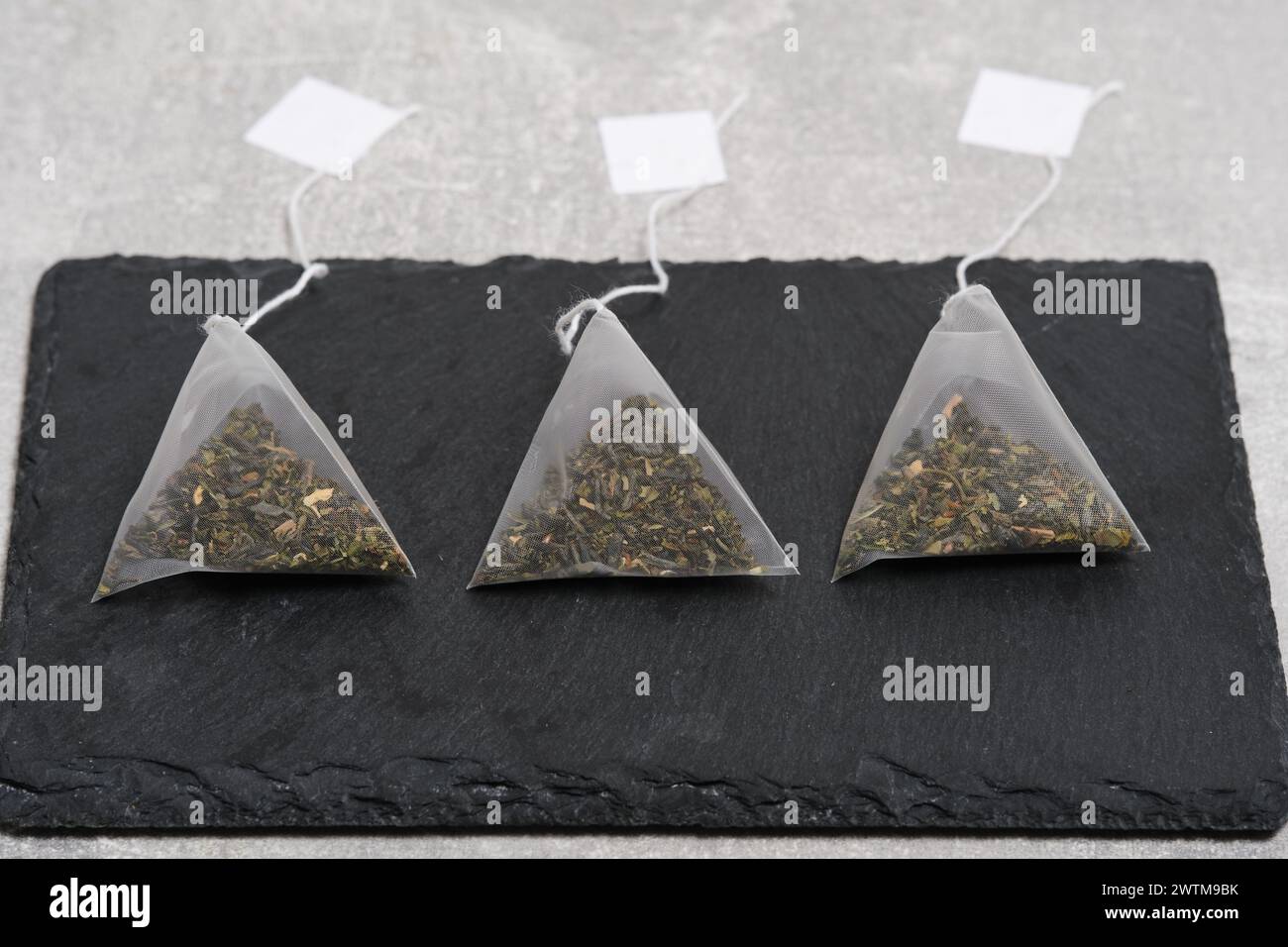 Triangular teabag with tea on a slate Stock Photo