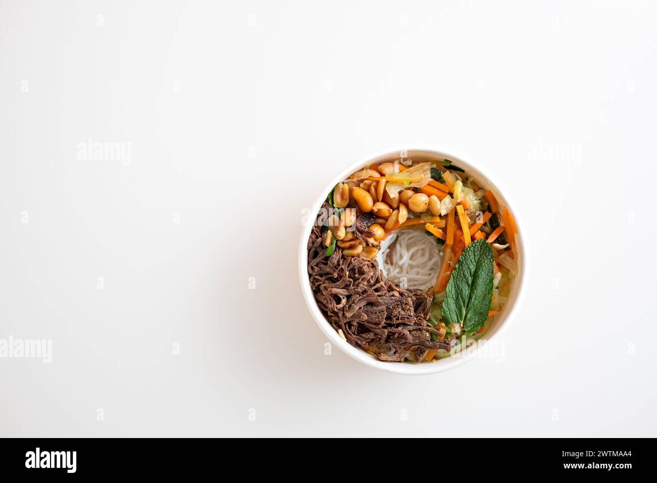 Cardboard bowl of take out Asian ramen noodles with pulled beef, rice ...