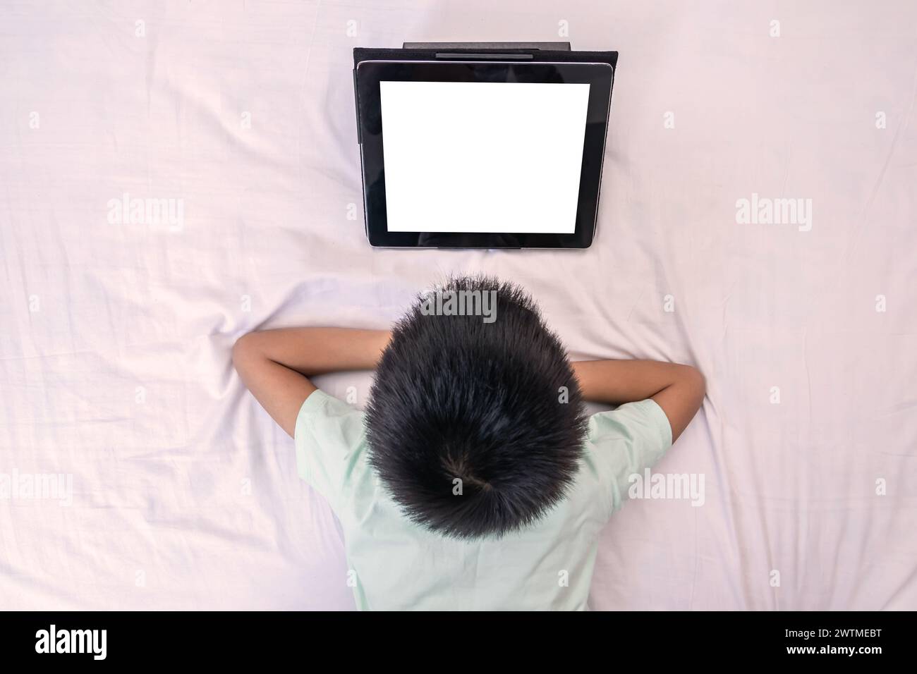 Top view little boy looking tablet and playing game while lying on the ...