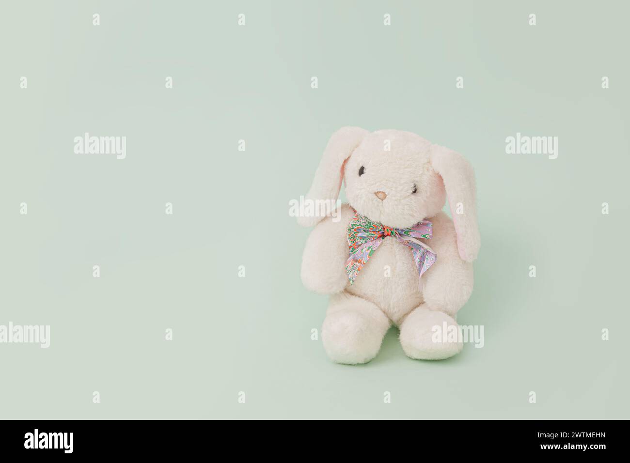 White plush toy rabbit isolated on pale green background; bunny front view Stock Photo
