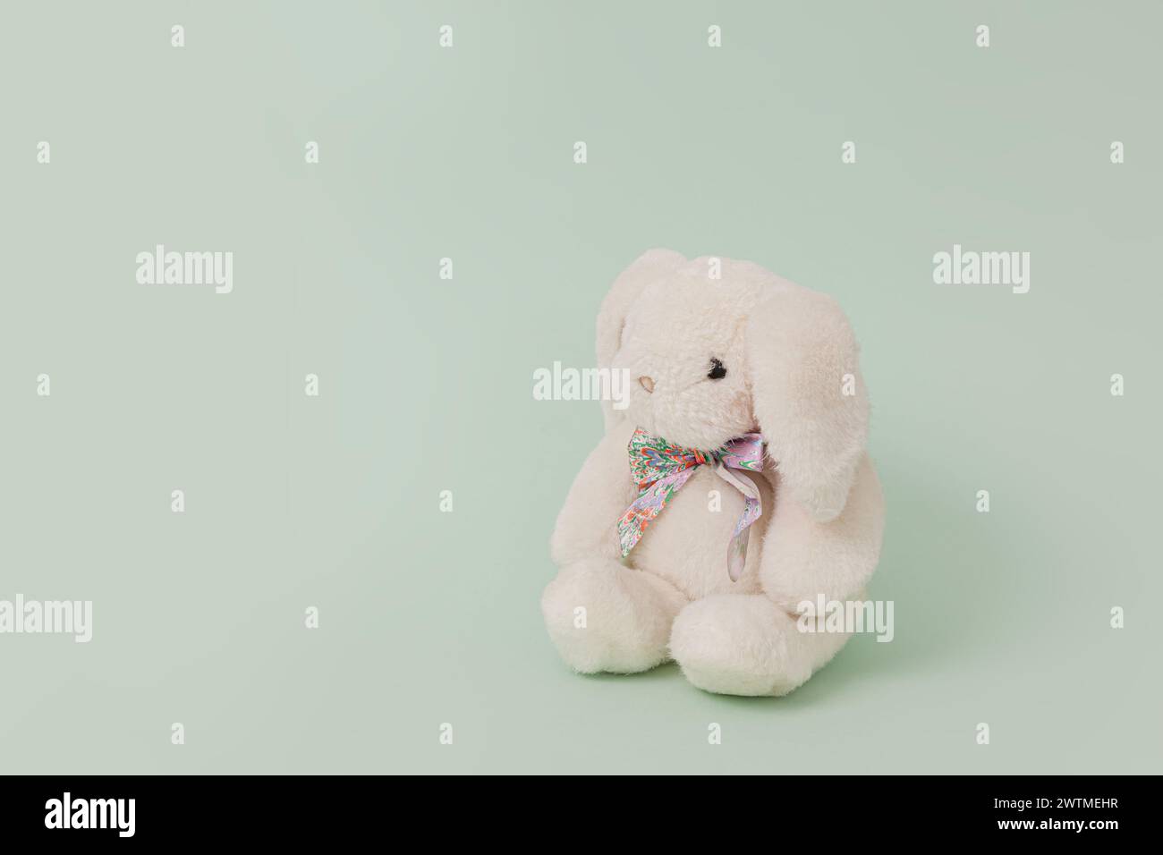 White plush toy rabbit isolated on pale green background; bunny perspective view Stock Photo