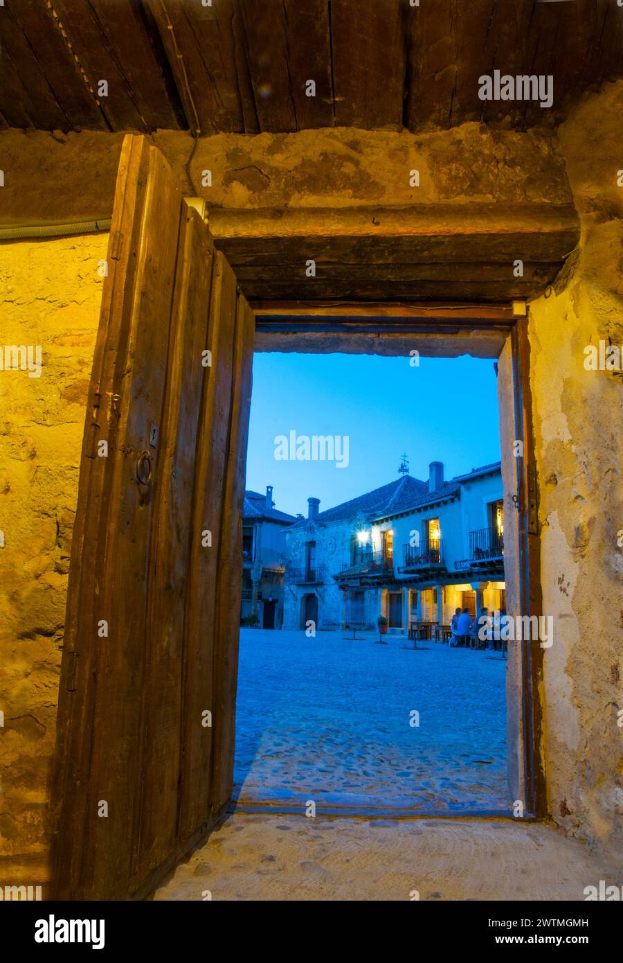 Main Square viewed through an open door, night view. Pedraza, Segovia province, Castilla Leon, Spain. Stock Photo