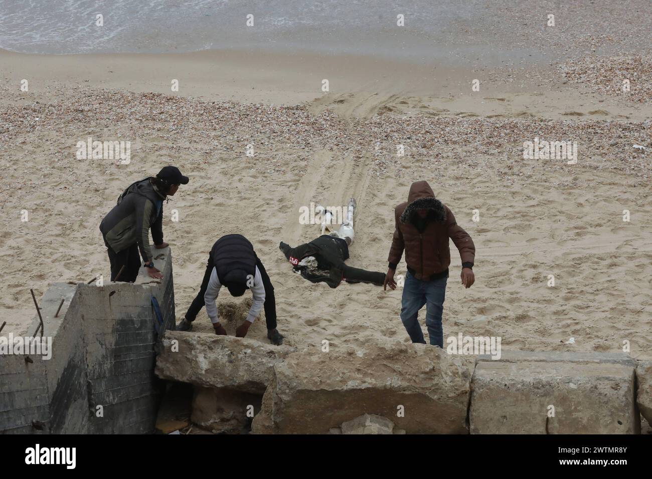 Palestinians prepare to bury a body on the beach near the Nuseirat ...