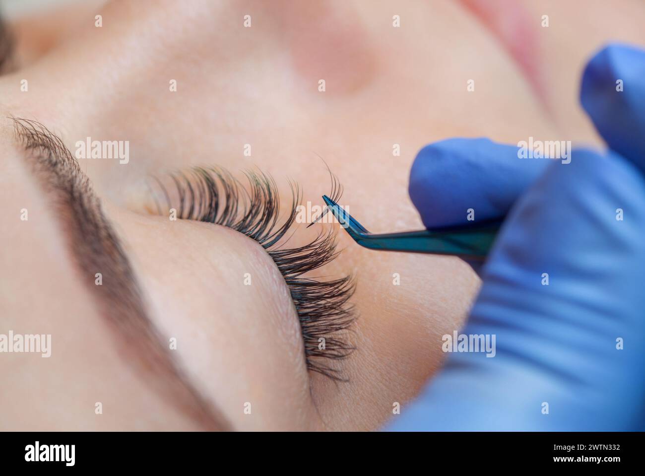 Beautiful Woman with long eyelashes in a beauty salon. Eyelash extension procedure. Lashes close up Stock Photo