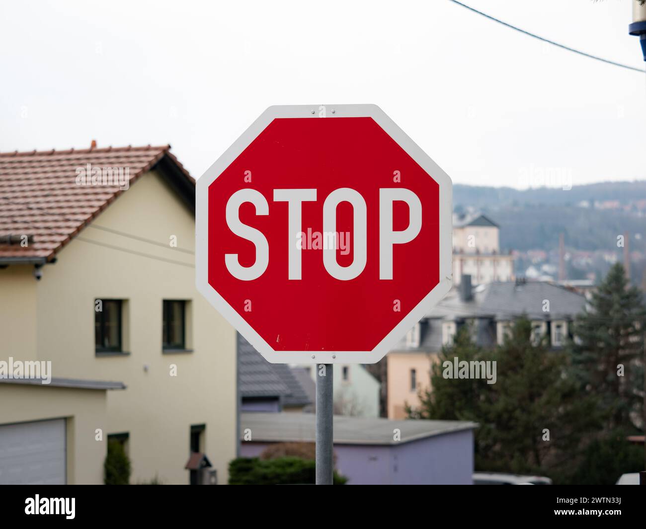 Stop road sign in Germany. Giving priority to other car drivers at the intersection of a side street. Warning signage as traffic regulation. Stock Photo