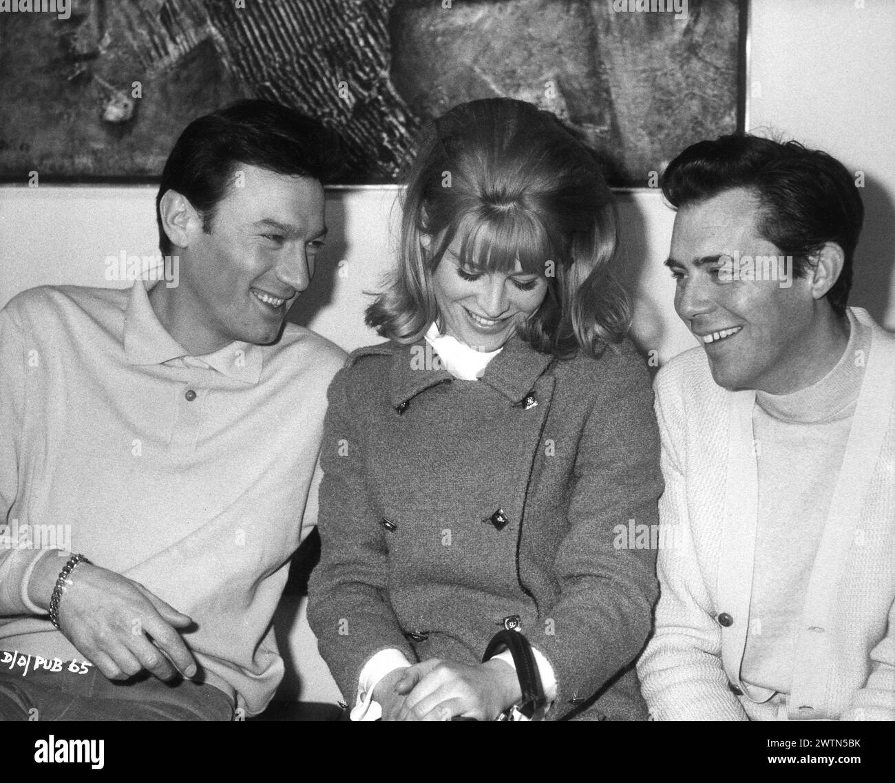 A candid photo of British Actress JULIE CHRISTIE with LAURENCE HARVEY and DIRK BOGARDE on the set of DARLING 1965  Director JOHN SCHLESINGER  Screenplay FREDERIC RAPHAEL Costume Design JULIE HARRIS Music JOHN DANKWORTH Vic-Appia Films / Anglo Amalgamated Stock Photo